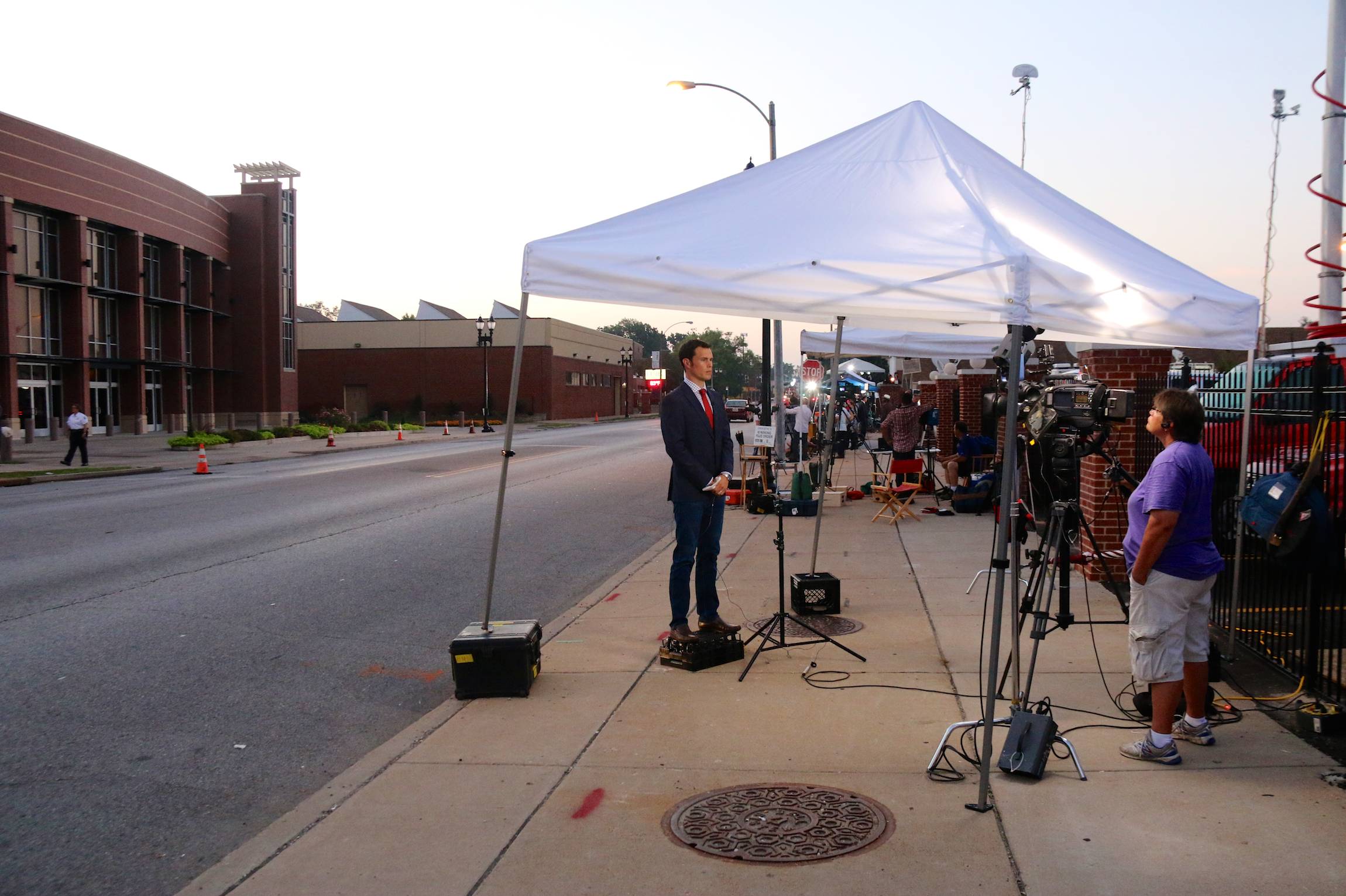 A reporter stands on a box for a live stand-up in front of the Friendly Temple Baptist church in St. Louis ahead of the funeral service for Michael Brown, Monday, August 25, 2014. (Yann Schreiber, File)