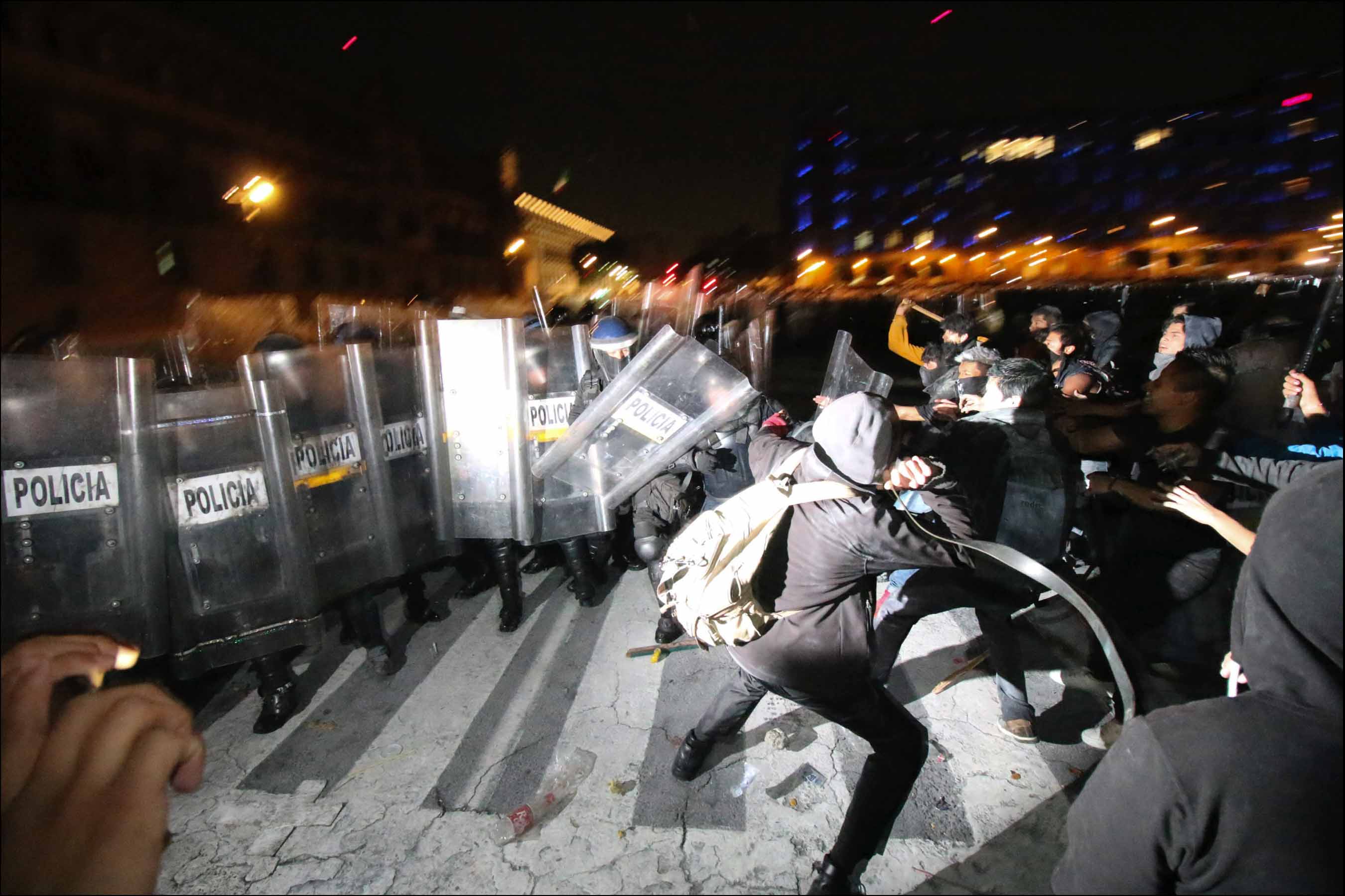 Mexican police and protesters clash at a rally in Mexico City, D.F, Mexico, Thursday, Nov. 20, 2014. The rally followed similar, partly violent demonstrations in the country since the disappearance of 43 students in Guerrero State and was primarily against president Enrique Peña Nieto, asking him to step down.