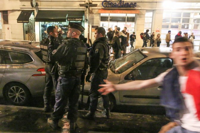 Un fan de football passe devant des gendarmes le 3 juillet 2016 à Paris.